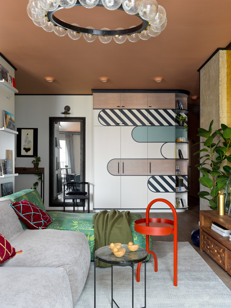На фото: парадная, объединенная гостиная комната среднего размера в стиле фьюжн с разноцветными стенами, полом из ламината, телевизором на стене, зоной отдыха и коричневым полом с