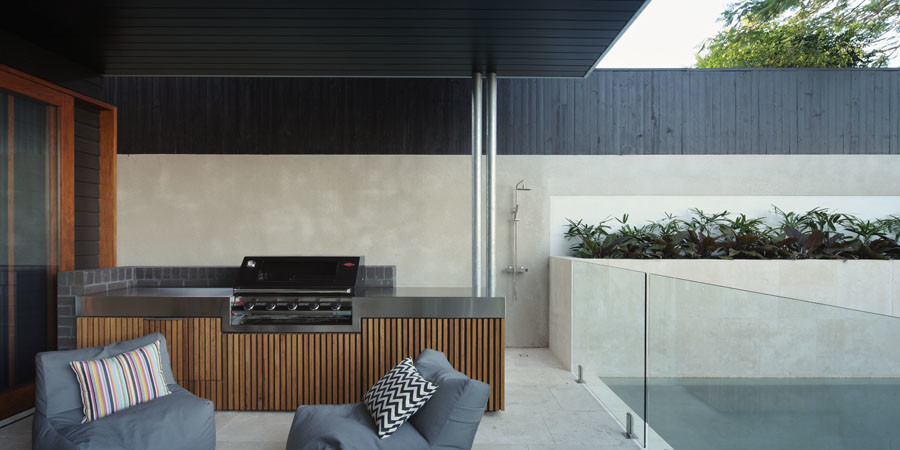 Contemporary backyard verandah in Brisbane with an outdoor kitchen and concrete pavers.