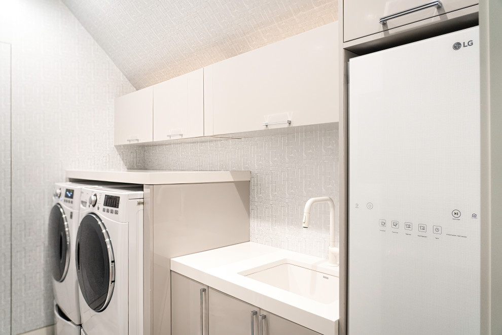 Idee per una sala lavanderia minimalista con lavello sottopiano, ante lisce, top in quarzo composito, pareti multicolore, lavatrice e asciugatrice affiancate, top bianco e carta da parati