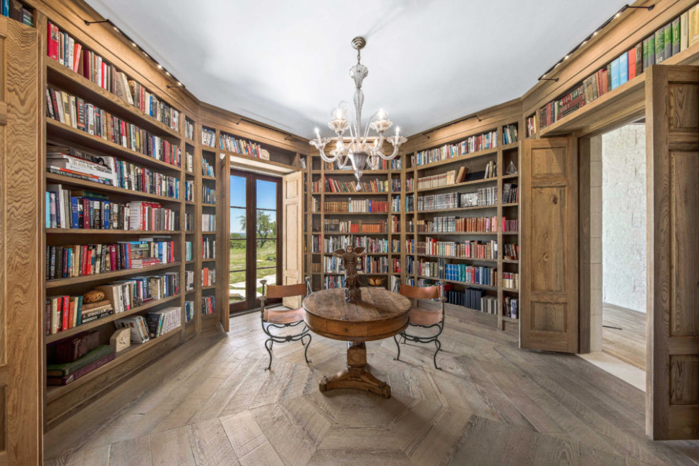 Ispirazione per un grande studio rustico con libreria, pavimento in legno massello medio, scrivania autoportante, pavimento marrone e pareti in legno