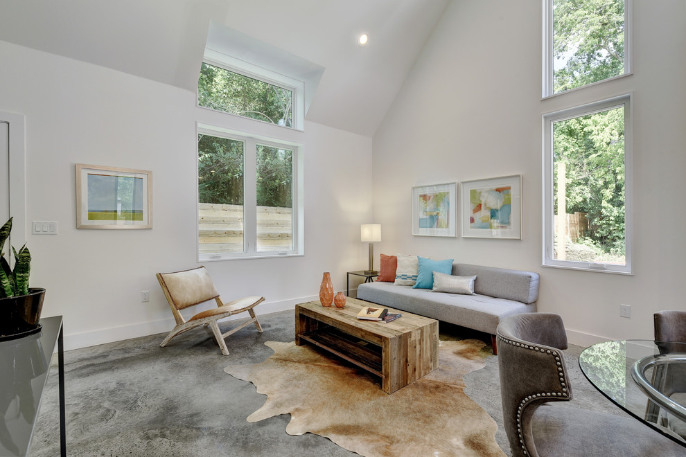Contemporary open concept living room in Austin with white walls and concrete floors.