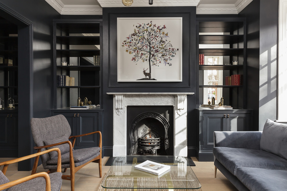 Mid-sized transitional formal enclosed living room in London with black walls, light hardwood floors, a standard fireplace and beige floor.
