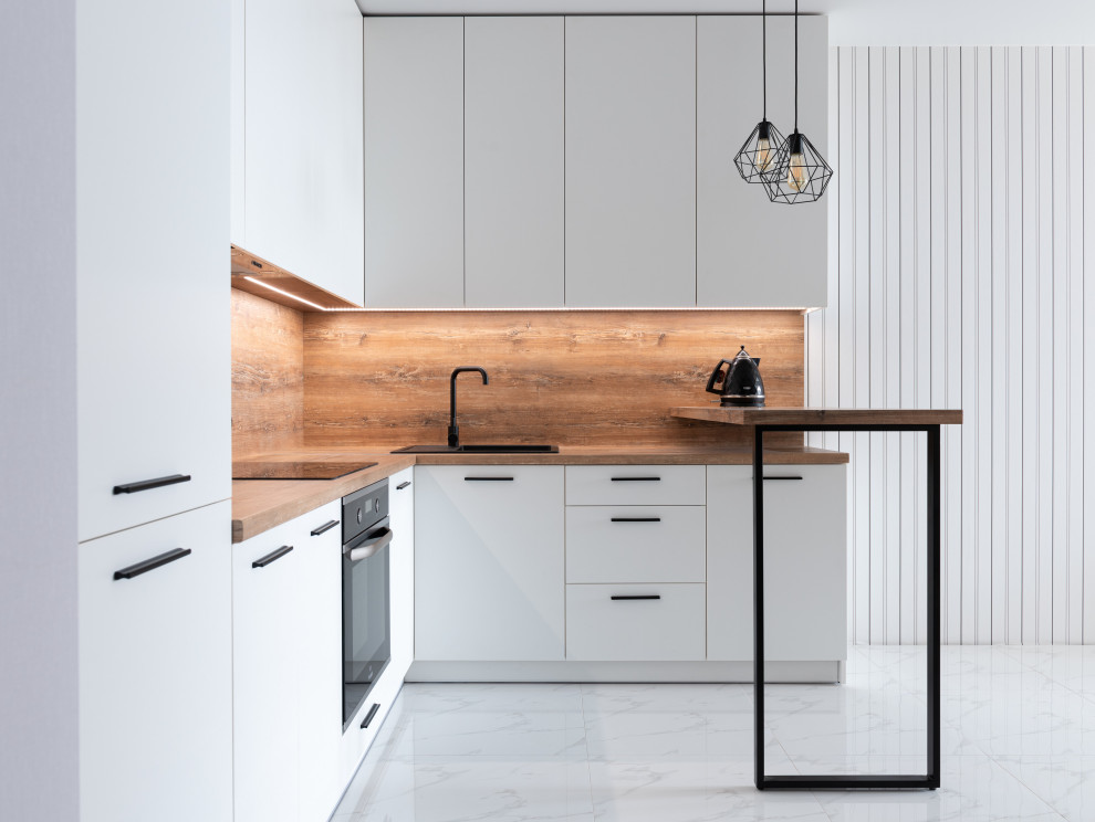 Medium sized modern l-shaped open plan kitchen in Sydney with white cabinets, wood worktops, wood splashback, an island, brown worktops, a single-bowl sink, flat-panel cabinets, brown splashback, black appliances, porcelain flooring and white floors.