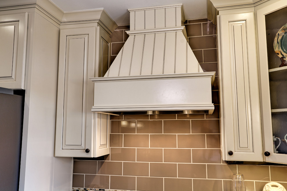 Inspiration for a mid-sized transitional u-shaped vinyl floor and brown floor eat-in kitchen remodel with an undermount sink, raised-panel cabinets, beige cabinets, quartz countertops, brown backsplash, porcelain backsplash, stainless steel appliances and an island