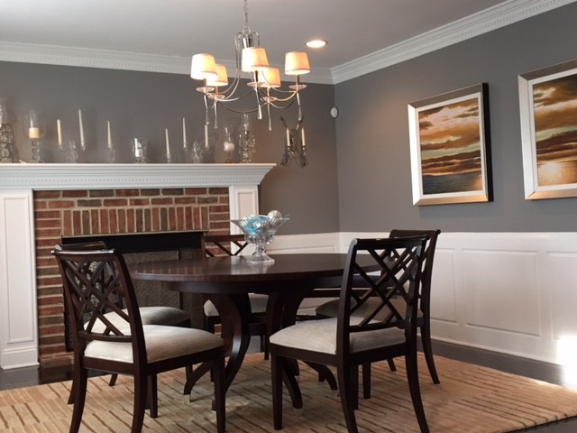 Mid-sized transitional kitchen/dining combo in New York with grey walls, dark hardwood floors, a standard fireplace and a brick fireplace surround.