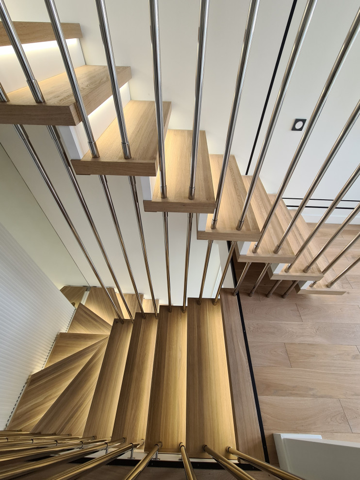 На фото: большая п-образная деревянная лестница в современном стиле с деревянными ступенями, металлическими перилами и кирпичными стенами
