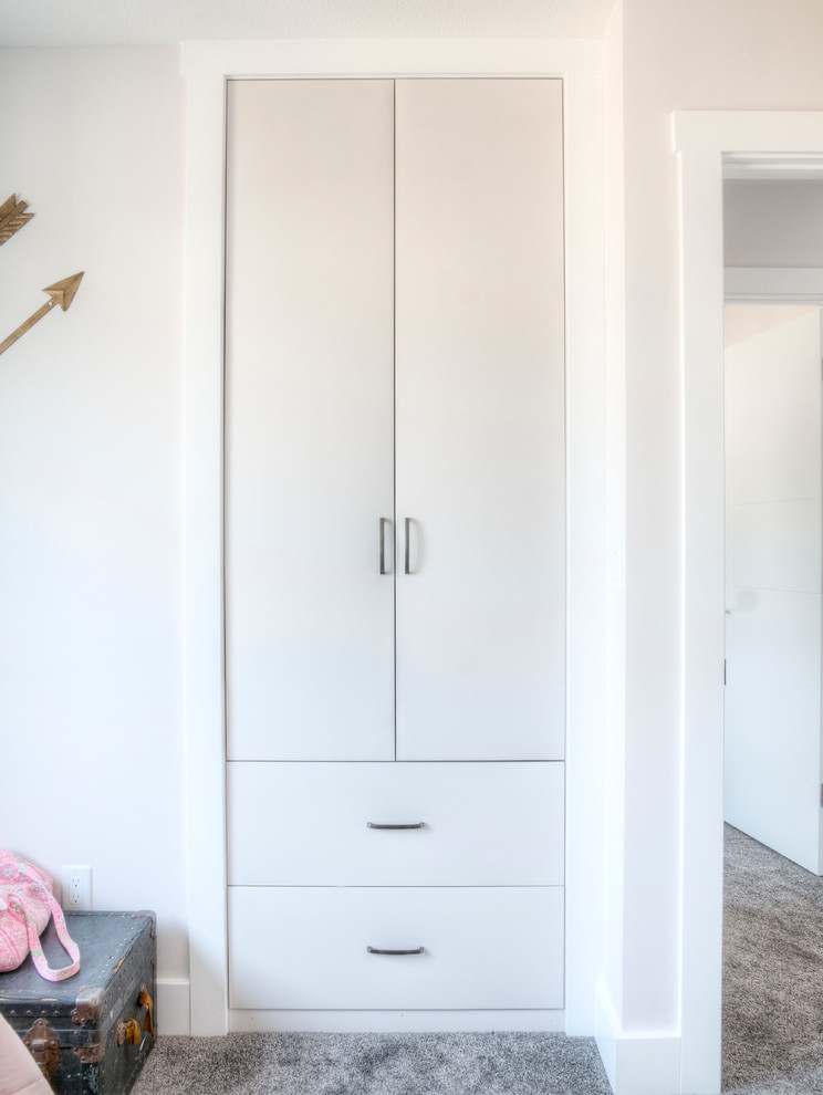 Inspiration for a small modern gender-neutral built-in wardrobe in Calgary with grey cabinets, carpet and grey floor.