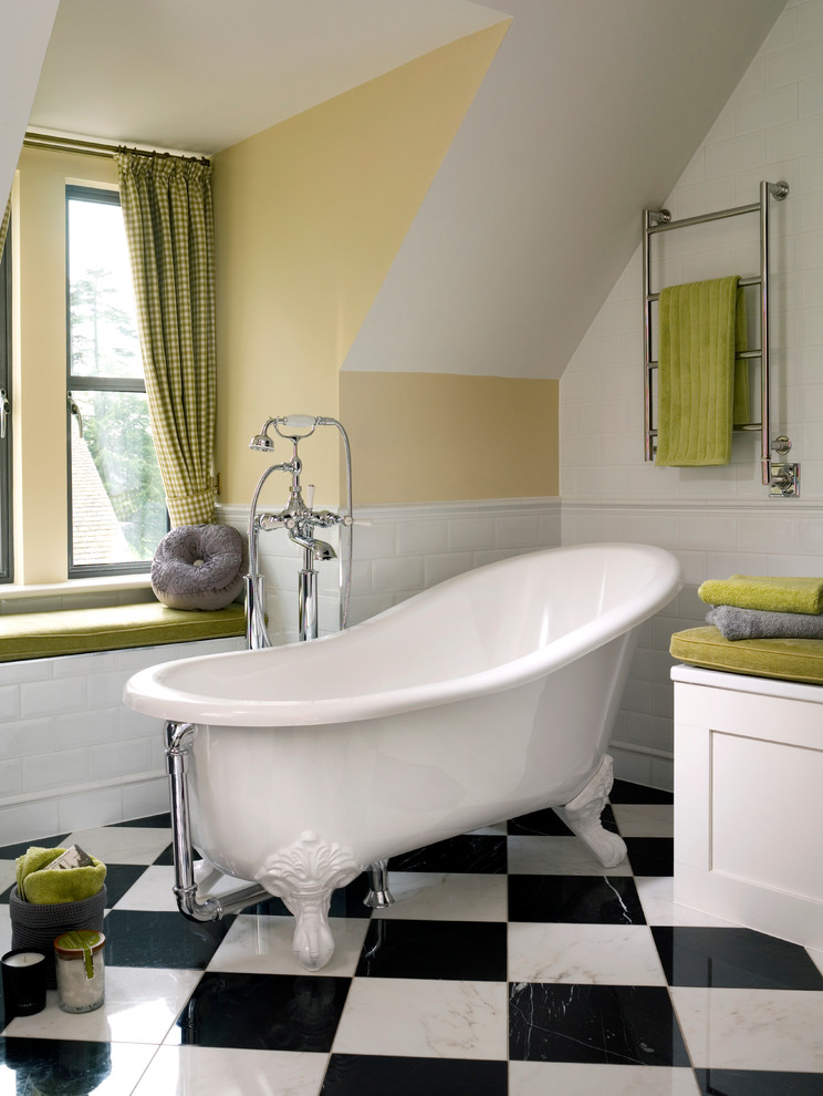 Design ideas for a small transitional bathroom in Surrey with recessed-panel cabinets, white cabinets, a claw-foot tub, white tile, ceramic tile, porcelain floors and yellow walls.