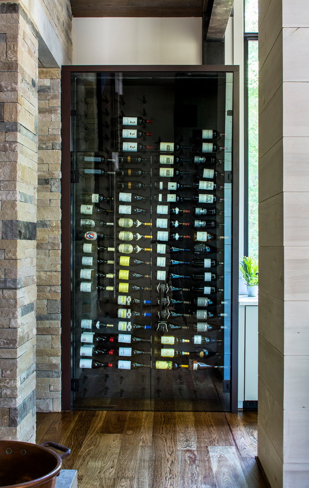 Country wine cellar in Atlanta with dark hardwood floors, storage racks and brown floor.