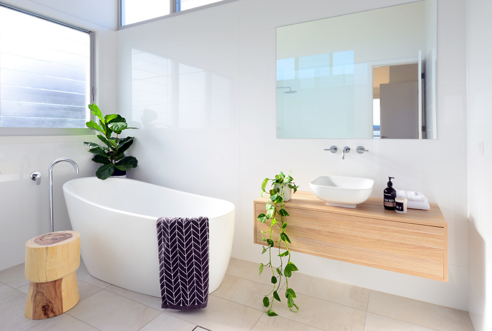 Inspiration for a small contemporary 3/4 bathroom in Wollongong with a freestanding tub, white tile, ceramic floors, a vessel sink, wood benchtops, beige floor, flat-panel cabinets, medium wood cabinets and brown benchtops.