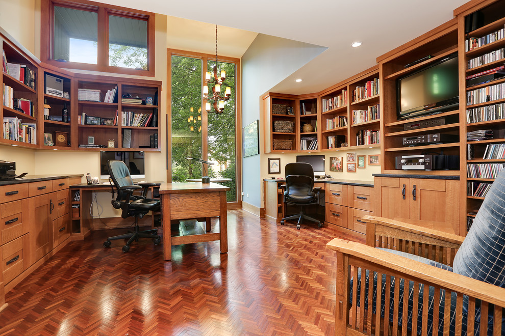 Photo of a large midcentury study room in Chicago with yellow walls, medium hardwood floors, a built-in desk, multi-coloured floor, no fireplace, wallpaper and wallpaper.