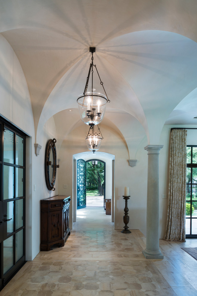 Design ideas for an expansive mediterranean entry hall in Houston with white walls, limestone floors, a single front door, a metal front door and beige floor.