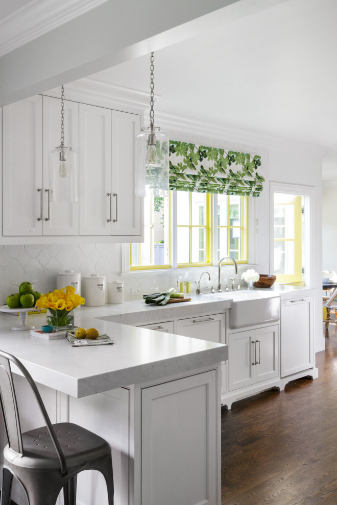 Photo of a large traditional kitchen in San Francisco with a farmhouse sink, shaker cabinets, white cabinets, white splashback, subway tile splashback, panelled appliances, dark hardwood floors, brown floor, white benchtop and coffered.