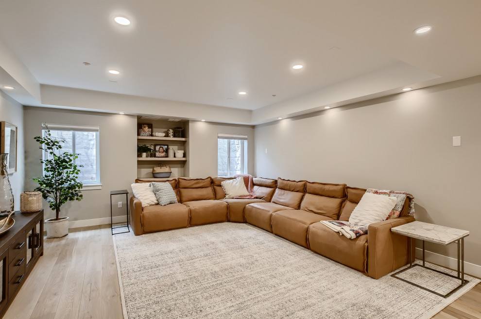 This is an example of a large mediterranean look-out basement in Denver with grey walls, laminate floors and grey floors.