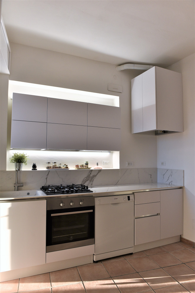 Modern inredning av ett linjärt kök med öppen planlösning, med en integrerad diskho, släta luckor, vita skåp och rosa golv