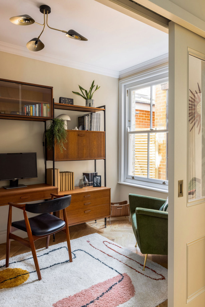 Foto de despacho retro de tamaño medio sin chimenea con paredes beige, suelo de madera en tonos medios, escritorio independiente y suelo beige