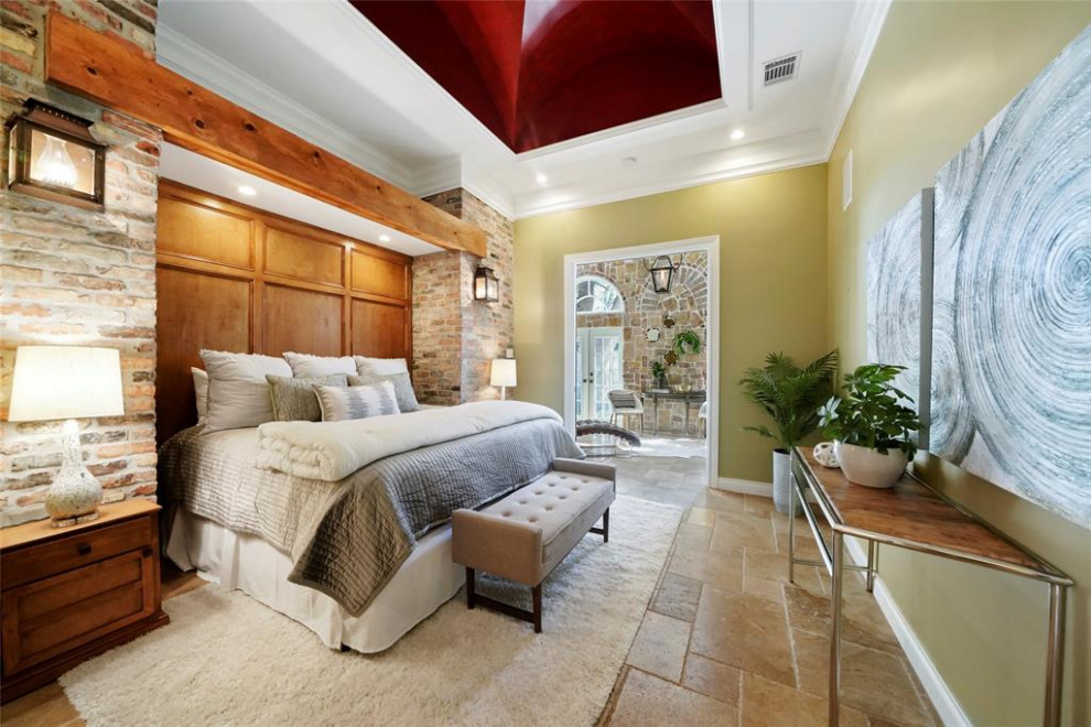 Inspiration pour une grande chambre parentale bohème avec un mur beige, un sol en travertin, un sol beige, un mur en parement de brique et un plafond voûté.