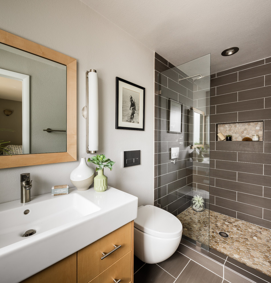 Photo of a small contemporary 3/4 bathroom in Denver with flat-panel cabinets, white cabinets, an alcove tub, a shower/bathtub combo, a wall-mount toilet, glass tile, purple walls, ceramic floors, an integrated sink, solid surface benchtops, grey floor, a shower curtain and white benchtops.