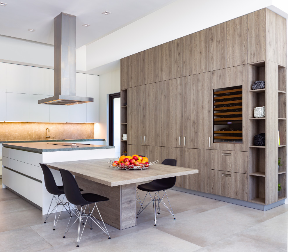This is an example of a large contemporary galley eat-in kitchen in Miami with a drop-in sink, flat-panel cabinets, light wood cabinets, quartz benchtops, grey splashback, engineered quartz splashback, panelled appliances, porcelain floors, with island, grey floor and grey benchtop.