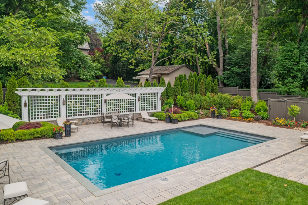 Inspiration for a large modern backyard rectangular infinity pool in Bridgeport with with a pool and concrete pavers.