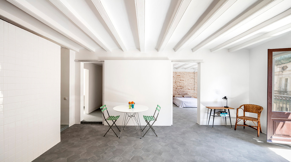 This is an example of a mid-sized mediterranean separate dining room in Barcelona with white walls, ceramic floors and no fireplace.