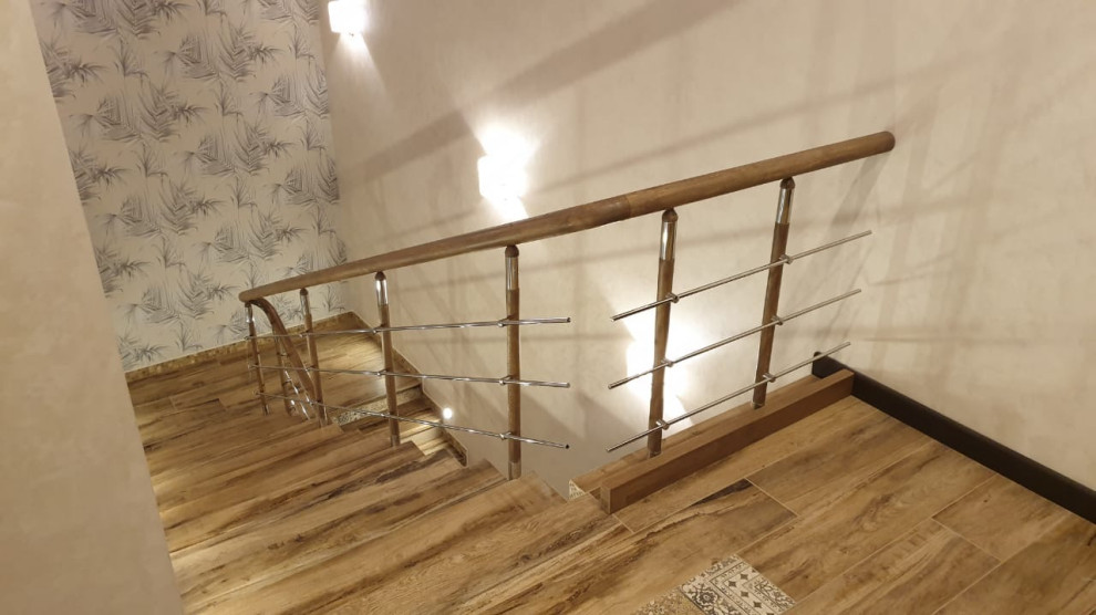Imagen de escalera recta moderna de tamaño medio con escalones de acrílico, contrahuellas con baldosas y/o azulejos, barandilla de madera y papel pintado