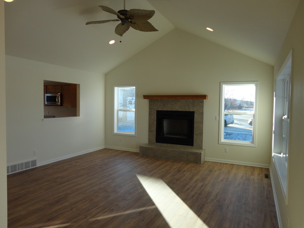 This is an example of a mid-sized traditional enclosed living room in Milwaukee with white walls, light hardwood floors and a standard fireplace.