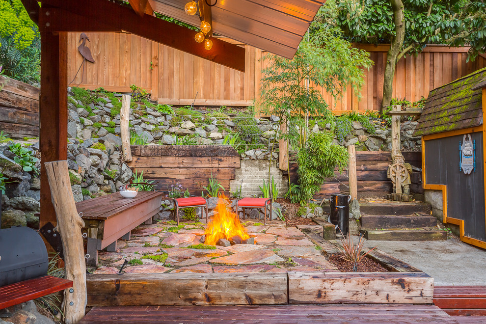 This is an example of a small beach style patio in Seattle with a fire feature.