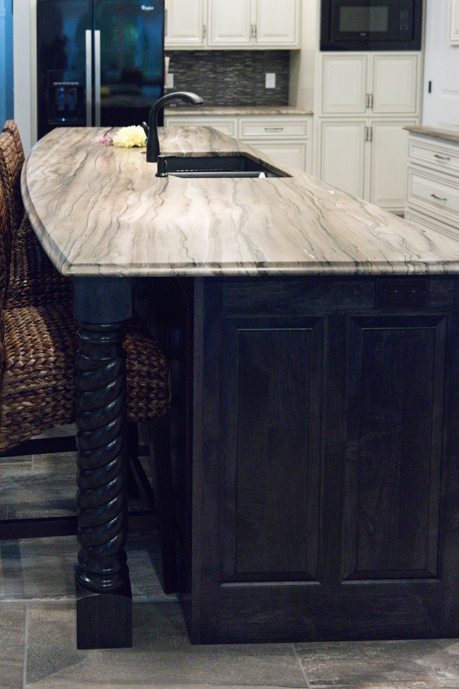 Example of a large transitional l-shaped ceramic tile eat-in kitchen design in Chicago with an undermount sink, raised-panel cabinets, dark wood cabinets, marble countertops, brown backsplash, glass tile backsplash, black appliances and an island