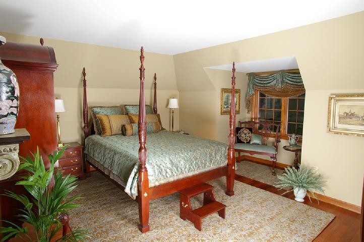Mid-sized traditional guest bedroom in New York with beige walls and carpet.