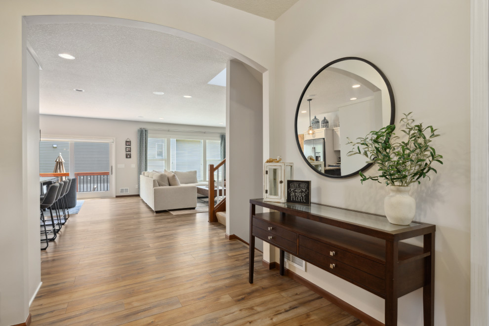Foyer - mid-sized transitional vinyl floor and brown floor foyer idea in Minneapolis with beige walls and a white front door