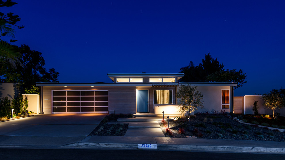 Photo of a small midcentury one-storey beige exterior in Orange County with mixed siding.