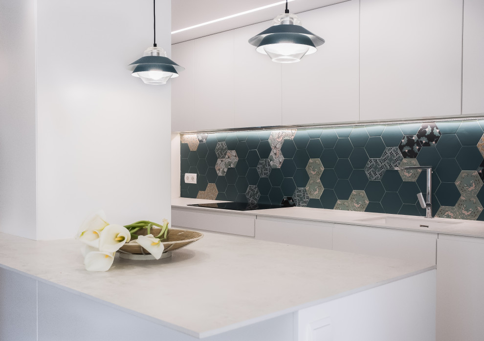 Design ideas for a mid-sized contemporary l-shaped eat-in kitchen in Valencia with an undermount sink, flat-panel cabinets, white cabinets, quartz benchtops, blue splashback, cement tile splashback, stainless steel appliances, porcelain floors, with island, grey floor and grey benchtop.