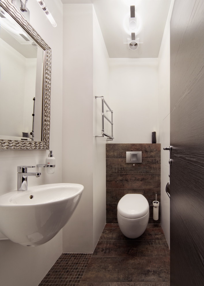 Inspiration for a small contemporary powder room in Moscow with a wall-mount toilet, brown tile, porcelain tile, white walls, porcelain floors, a wall-mount sink and brown floor.