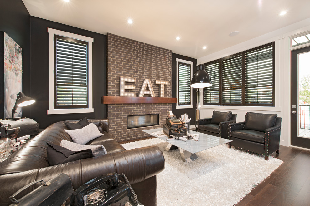 This is an example of a transitional living room in Calgary with black walls, dark hardwood floors, a ribbon fireplace and a brick fireplace surround.