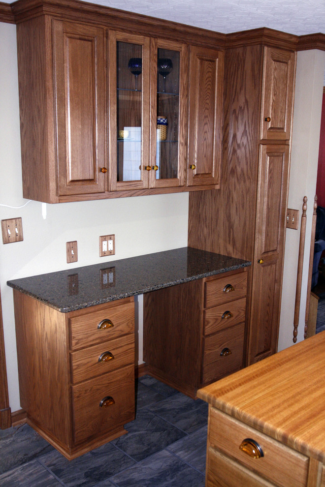Example of a mid-sized l-shaped eat-in kitchen design with an undermount sink, raised-panel cabinets, medium tone wood cabinets, quartz countertops, beige backsplash, stone tile backsplash, white appliances and an island
