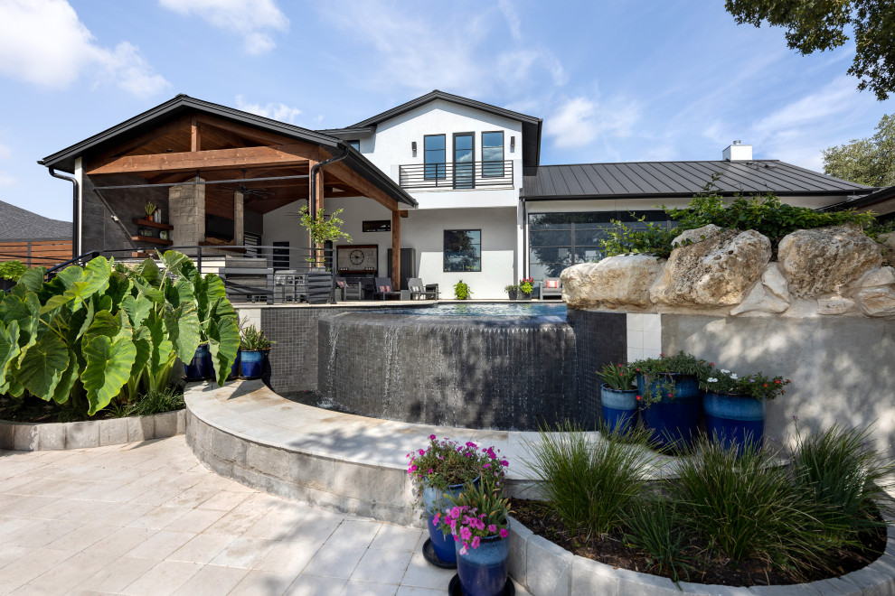 Modern back custom shaped swimming pool in Austin with with pool landscaping.