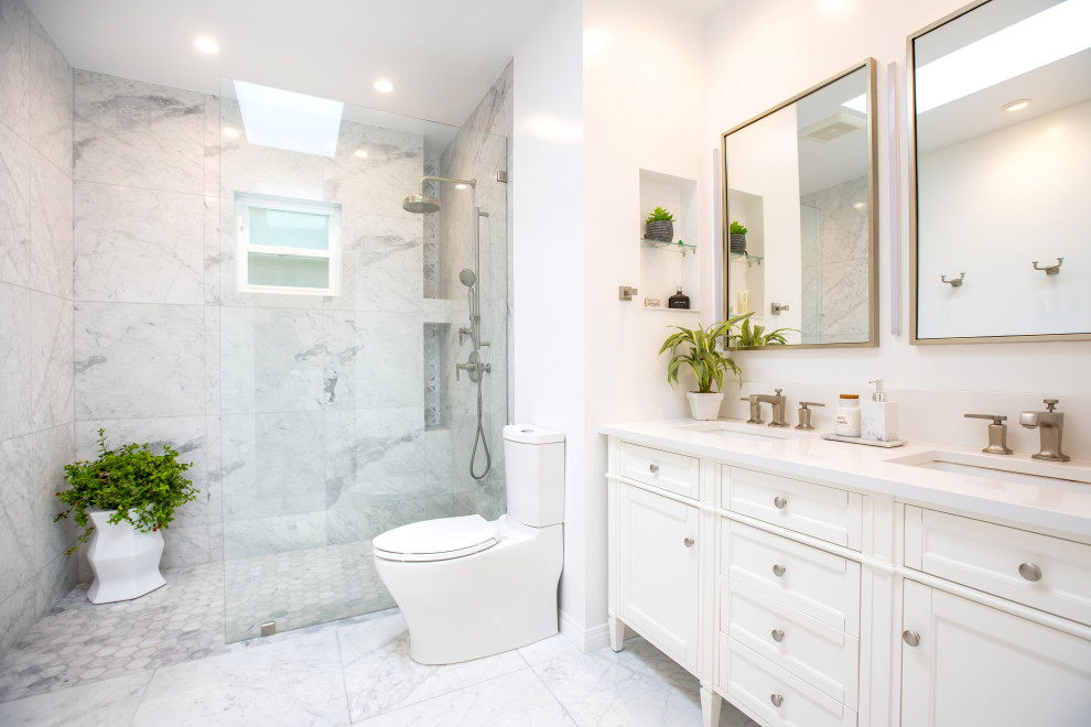 На фото: большая главная, серо-белая ванная комната в стиле неоклассика (современная классика) с фасадами в стиле шейкер, белыми фасадами, открытым душем, раздельным унитазом, разноцветной плиткой, мраморной плиткой, белыми стенами, мраморным полом, врезной раковиной, столешницей из искусственного кварца, разноцветным полом, душем с распашными дверями, белой столешницей, нишей, окном, тумбой под две раковины и напольной тумбой