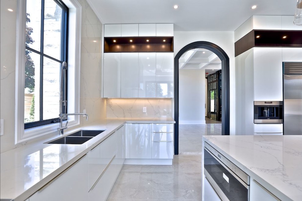 This is an example of a large modern kitchen in Toronto with an undermount sink, flat-panel cabinets, white cabinets, quartz benchtops, yellow splashback, marble splashback, stainless steel appliances, porcelain floors, with island, beige floor and yellow benchtop.