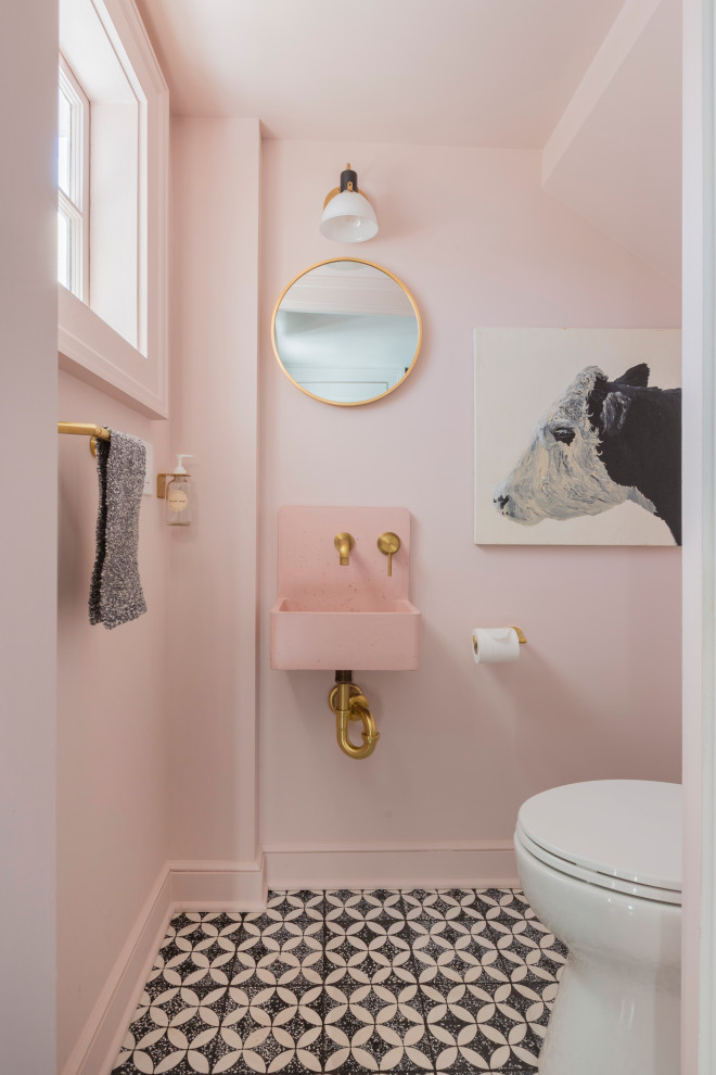 Kleine Klassische Gästetoilette mit Wandtoilette mit Spülkasten, rosa Wandfarbe, Zementfliesen für Boden, Wandwaschbecken, schwarzem Boden und rosa Waschtischplatte in New York