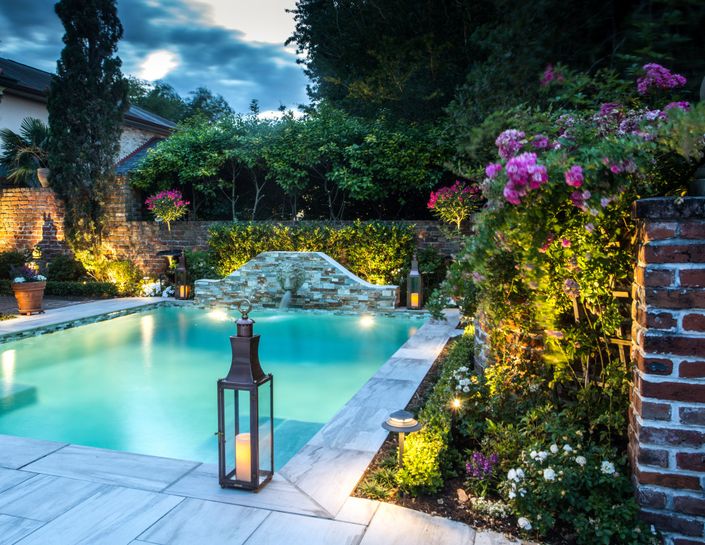 Diseño de piscina con fuente ecléctica de tamaño medio rectangular en patio trasero con suelo de baldosas
