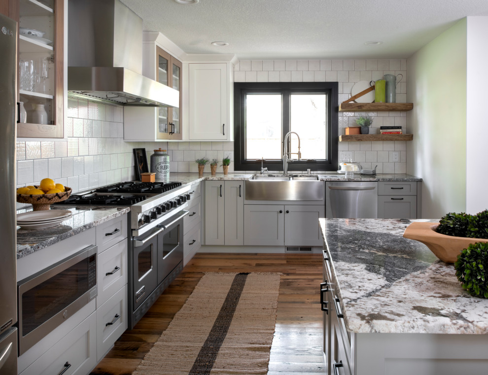 Inredning av ett rustikt mellanstort flerfärgad flerfärgat kök, med en rustik diskho, skåp i shakerstil, vita skåp, vitt stänkskydd, stänkskydd i keramik, rostfria vitvaror, mellanmörkt trägolv, en köksö och brunt golv