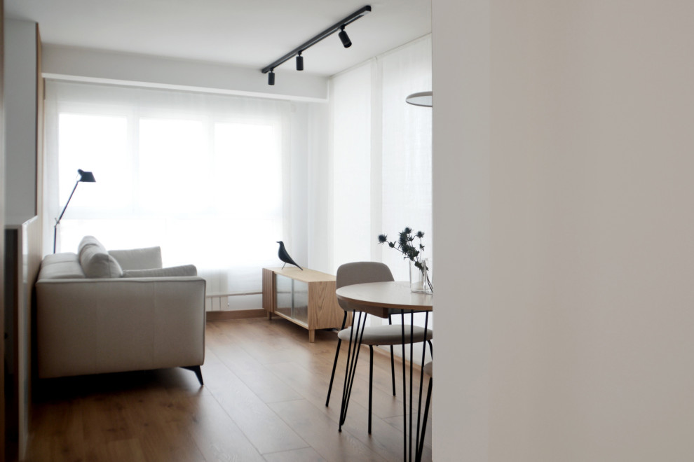 Kleines, Offenes Modernes Wohnzimmer mit weißer Wandfarbe und braunem Holzboden in Sonstige