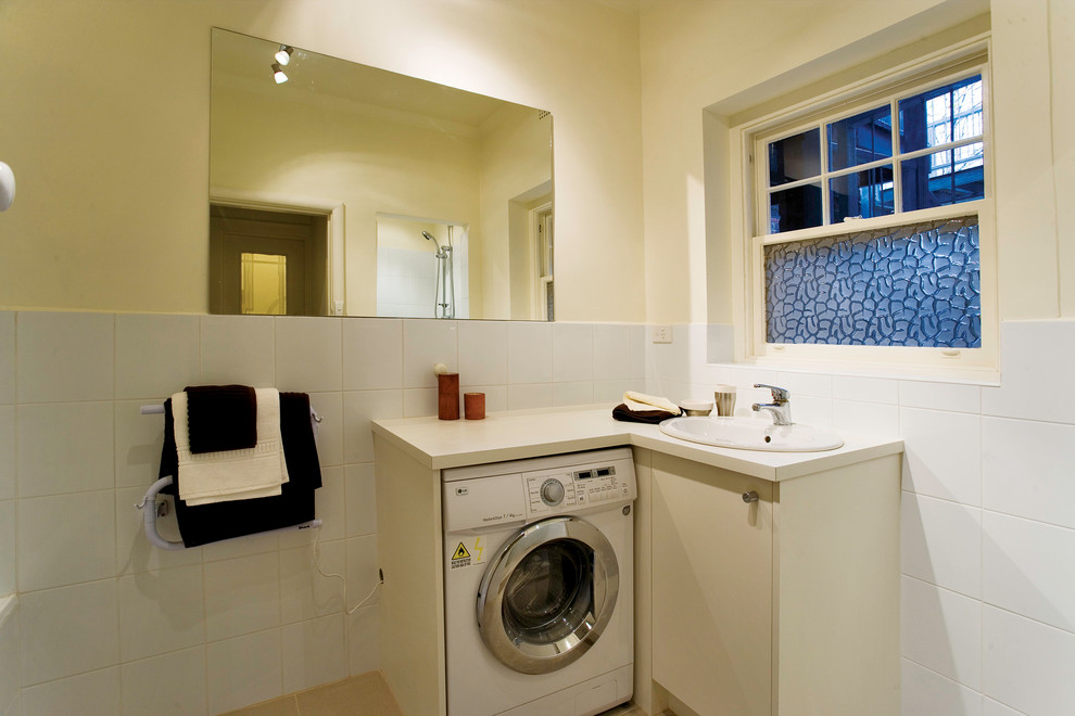 Small contemporary utility room in Melbourne with a drop-in sink, flat-panel cabinets, white cabinets, laminate benchtops, white walls and ceramic floors.