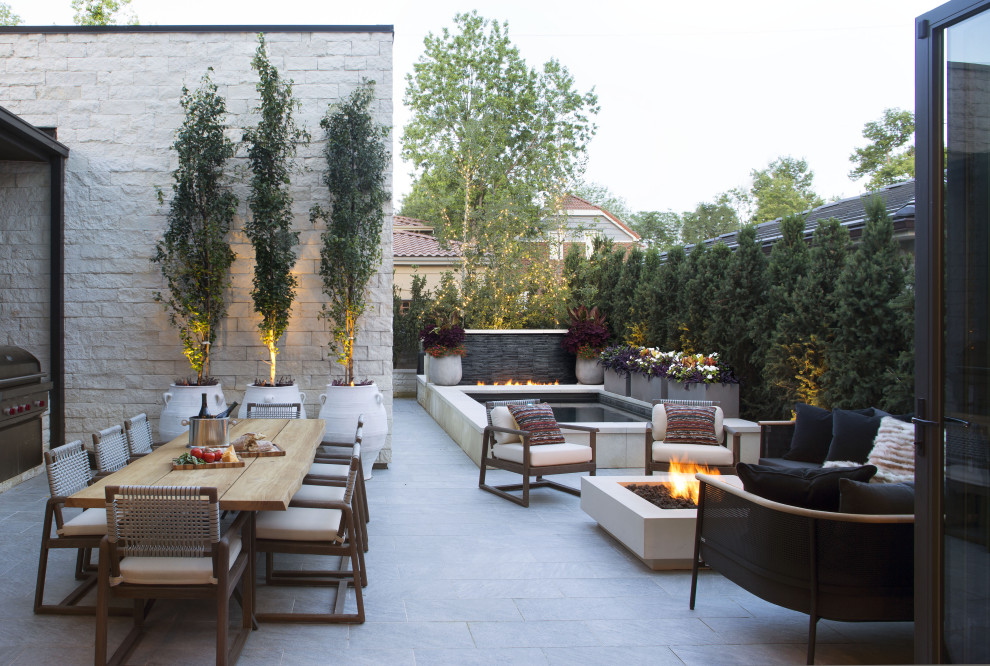 Example of a large trendy courtyard stone patio design in Denver with a fire pit and no cover