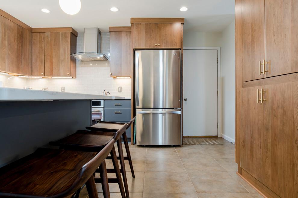 This is an example of a large midcentury l-shaped eat-in kitchen in Miami with an undermount sink, flat-panel cabinets, grey cabinets, quartz benchtops, beige splashback, subway tile splashback, stainless steel appliances, ceramic floors and with island.