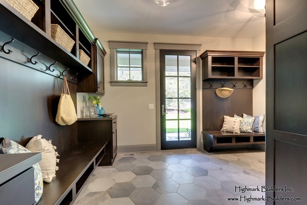 Mudroom - large traditional ceramic tile mudroom idea in Minneapolis with beige walls and a dark wood front door