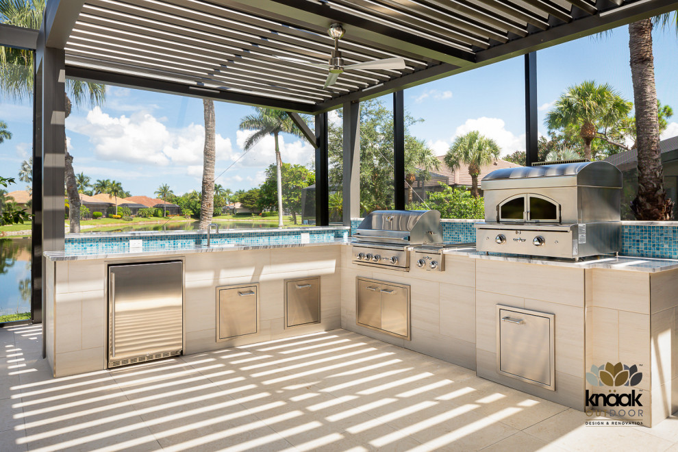 Photo of a medium sized coastal back ground level terrace in Miami with an outdoor kitchen and a pergola.