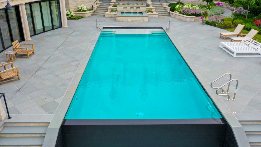 Pool landscaping - mid-sized traditional courtyard stone and rectangular lap pool landscaping idea in Chicago