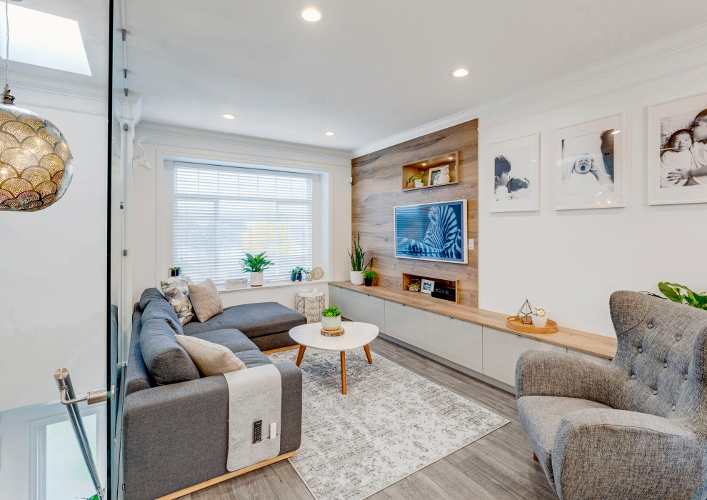 Example of a trendy enclosed medium tone wood floor, gray floor and wood wall living room design with white walls, no fireplace and a wall-mounted tv